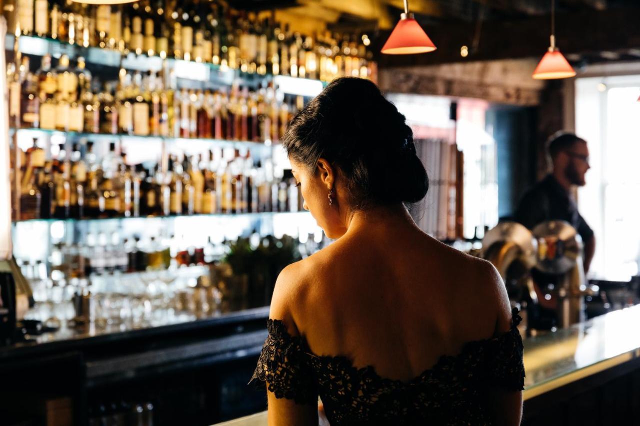 The Henry Jones Art Hotel Hobart Exterior photo A woman at a bar